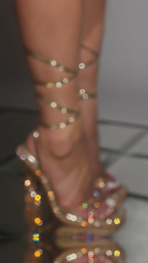Model wearing embellished gold heels video