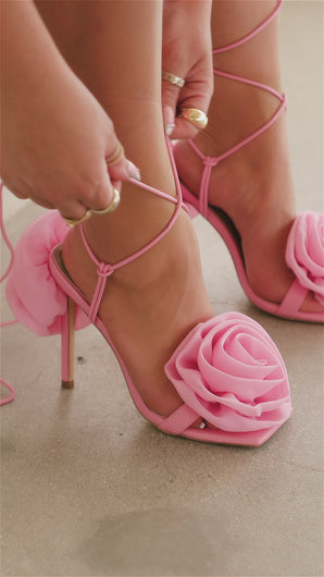 Woman lacing up rosette detailed heels