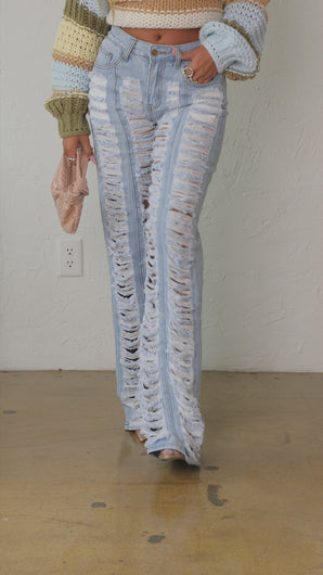 Model wearing distressed light wash jeans