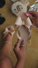 Load and play video in Gallery viewer, Video of nude jelly sandals with bow detail
