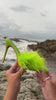 Model holding green feather embellished pump mule by the ocean video