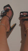 black heels with embellished bow straps on model