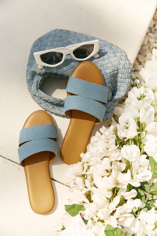 Load image into Gallery viewer, Denim Slip On Sandals Laying on Denim Bag Next to White Flowers
