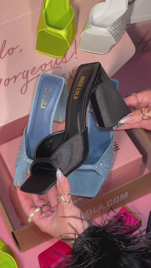 woman holding black satin chunky heel
