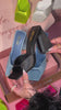 woman holding black satin chunky heel