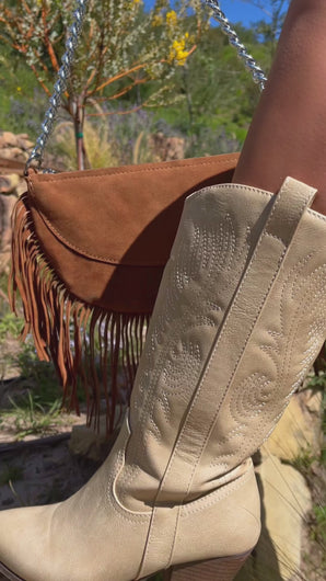 Brown suede bag with fringe detailing paired with ivory cowgirl boots