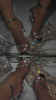 Woman wearing silver heels with embellished toe strap in front of mirror