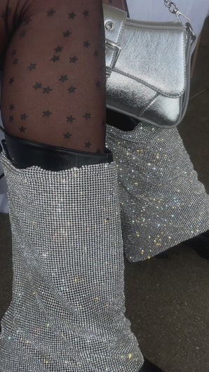 Model wearing black chunky platform boots with embellished draped detailing