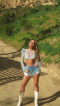 Load and play video in Gallery viewer, Model wearing denim shorts with feather trim detailing
